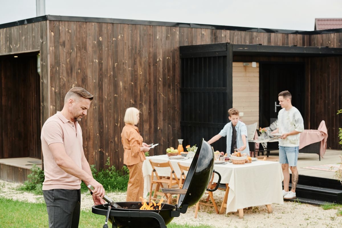 Friends around a barbecue in a sunny backyard